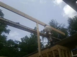 Carpenter setting a ridge beam over a new addition frame — Ice Dam Removal by Roofing Brothers in Bruneau