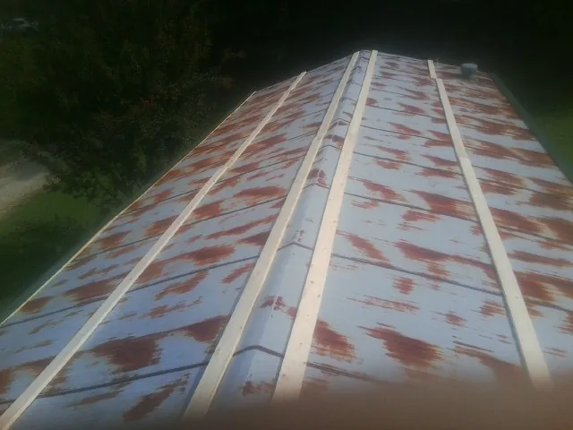 Rusted metal roof panels with new wood purlins before replacement — Storm Damage Roof Repair in Bruneau by Roofing Brothers
