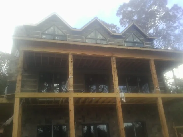 Dormers and porch framing on a large log home under construction — Roof Coating work by our crew in Bruneau