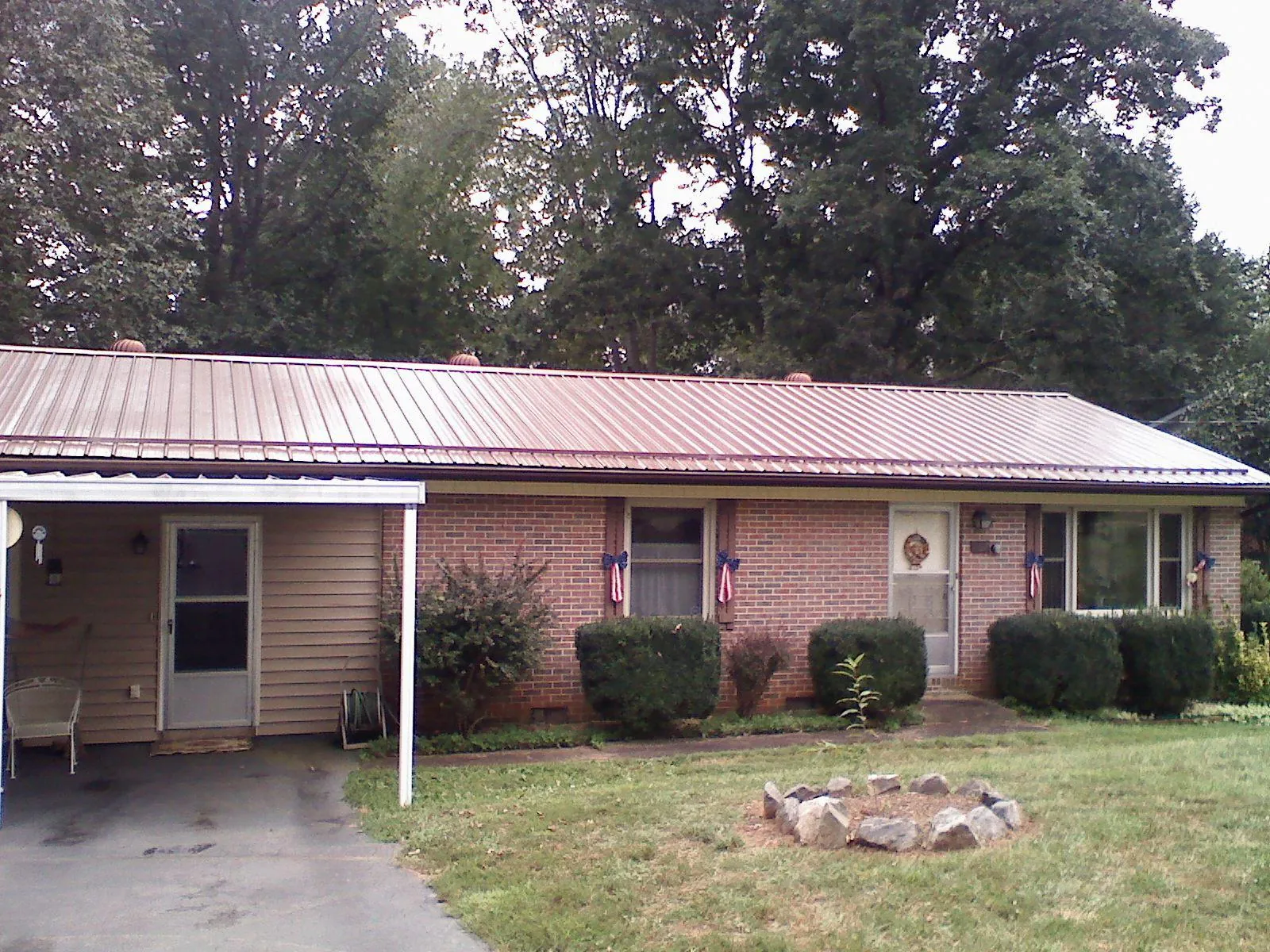 Bronze metal roof and carport on a brick ranch home — Roof Repair work by our crew in Bruneau